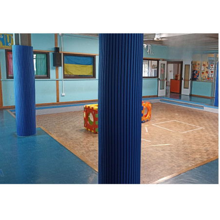 Protection de pilier cylindrique en TETRIS sur mesure dans une salle polyvalente: colonnes bleues anti-choc au centre et blocs T