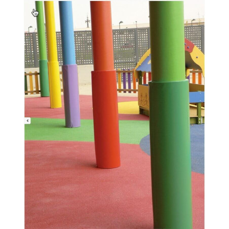Piliers cylindriques rembourrés et colorés dans une aire de jeux extérieure, sol multicolore et structure en bois en arrière-pla