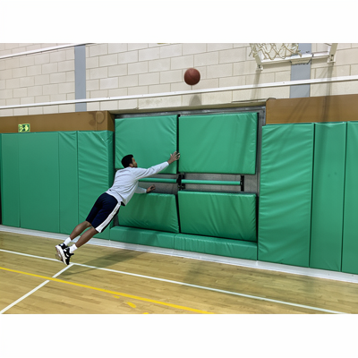 Protection murale verte sur mesure installée dans une salle de sport autour des portes