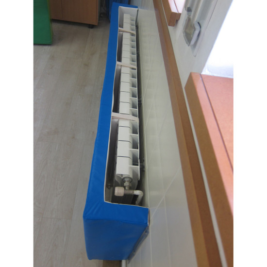 Poteau de protection avec gaine bleue et mécanisme gris, aligné le long d’un mur près d’une fenêtre, utilisé pour sécuriser les bâtiments.