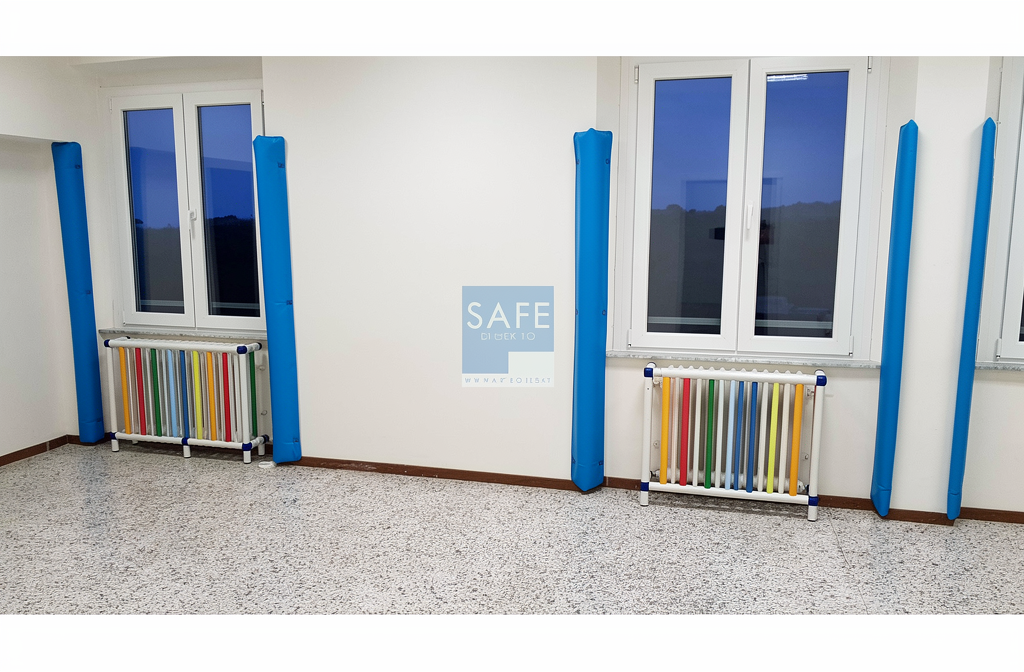 Protections d'angle bleues installées sur les coins de murs d'un couloir institutionnel.