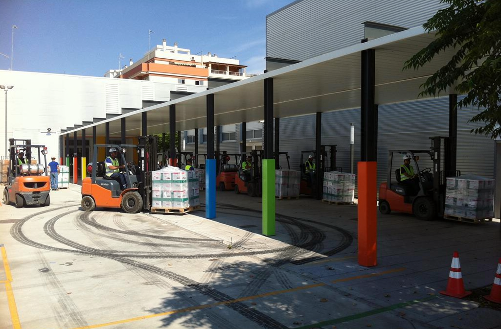 Protections de poteaux colorées installées dans une zone de quai de chargement d'entrepôt.