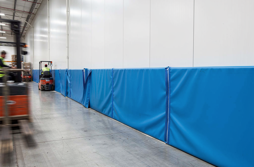 Lisse de protection murale bleue installée le long d’un mur intérieur, divise et protège les bas de mur dans un espace industriel. matériau PVC/murale en polyéthylène possible. Dimension sur mesure.