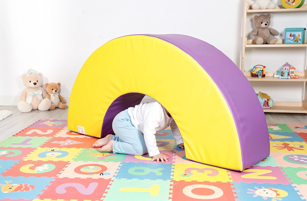 Textile coloré et arche gym fun sur sol ardoise, bébé rampe sous une structure douce pour activités psychomotriques 0 2 a.